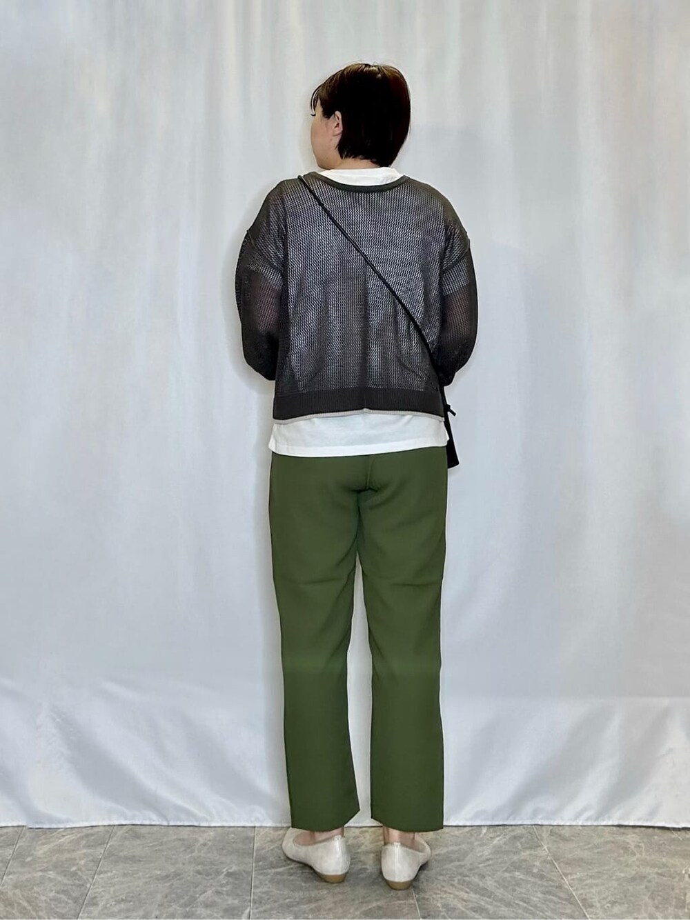 グレー系のその他トップス、グリーン系のその他パンツ、ゴールド系のその他シューズを着用したレディースの春コーディネートの3枚目の写真