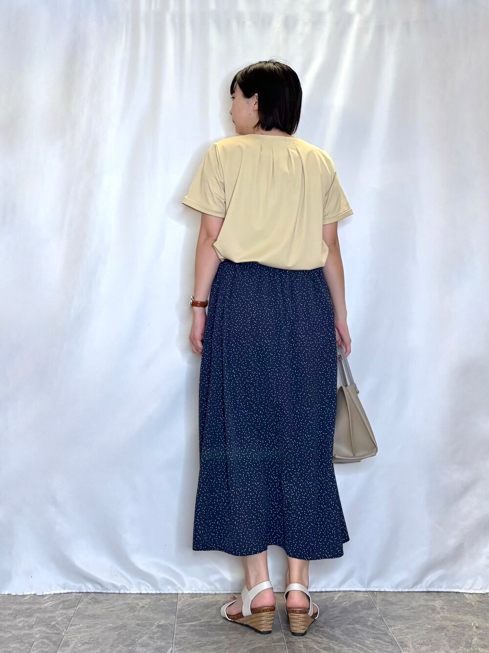 イエロー系のシャツ/ブラウス、ブルー系のスカート、ホワイト系のサンダルを着用したレディースの春コーディネートの3枚目の写真