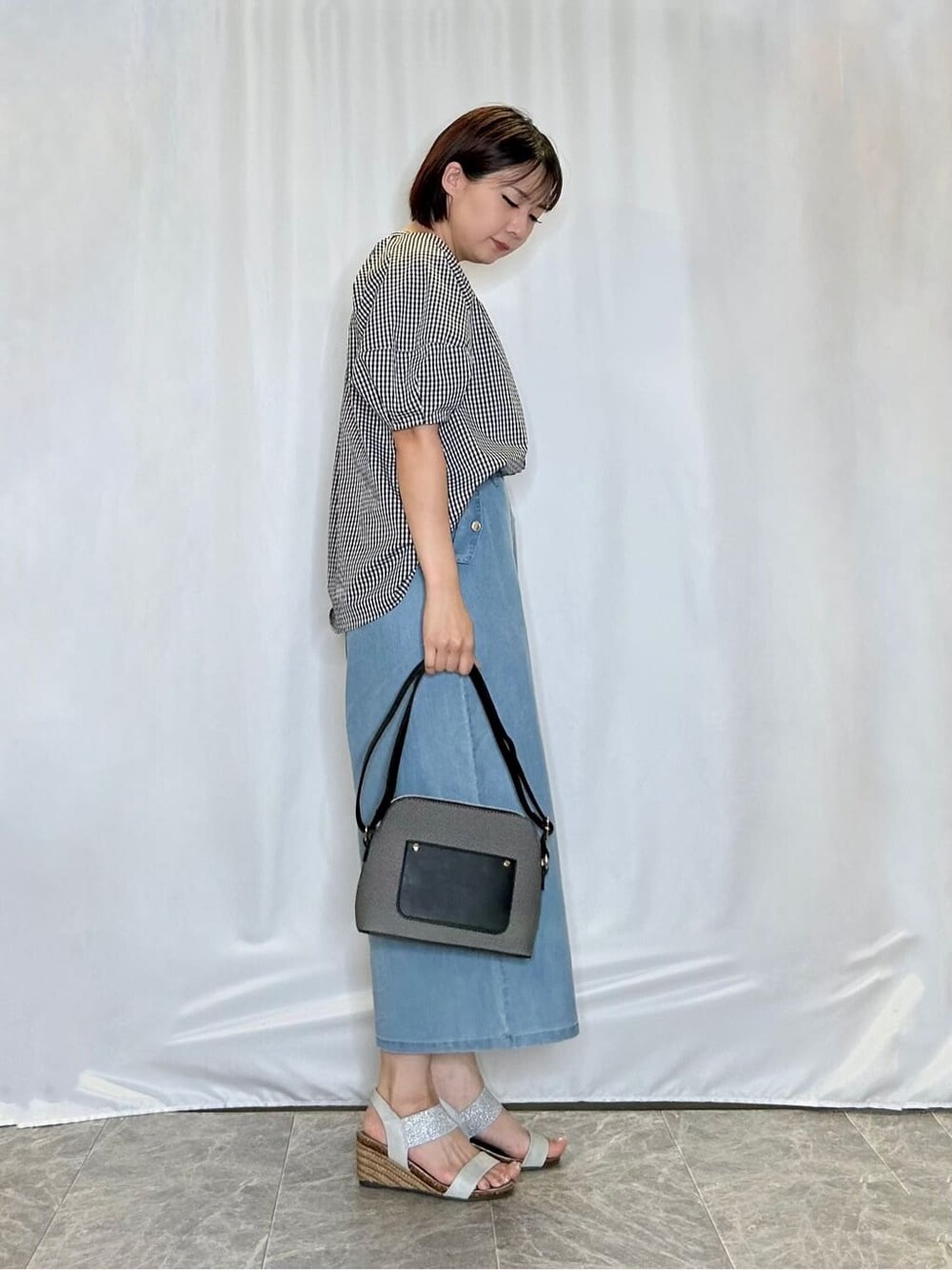 ブラック系のシャツ/ブラウス、ブルー系のデニムパンツ、シルバー系のサンダルを着用したレディースの夏コーディネートの2枚目の写真