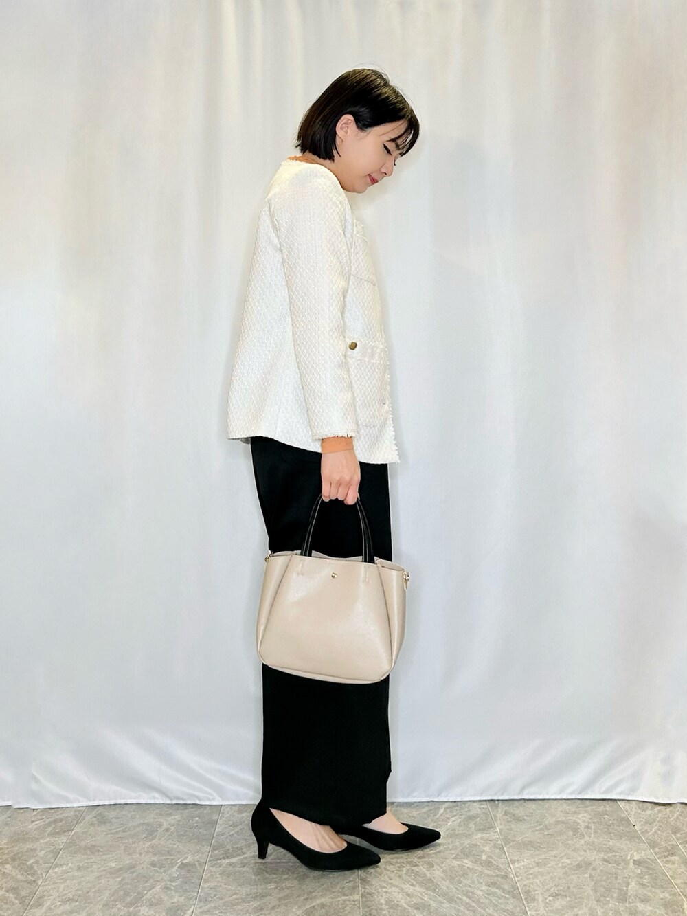 ブラック系のパンプス、ベージュ系のトートバッグ、ベージュ系のノーカラージャケットを着用したレディースの秋コーディネートの2枚目の写真