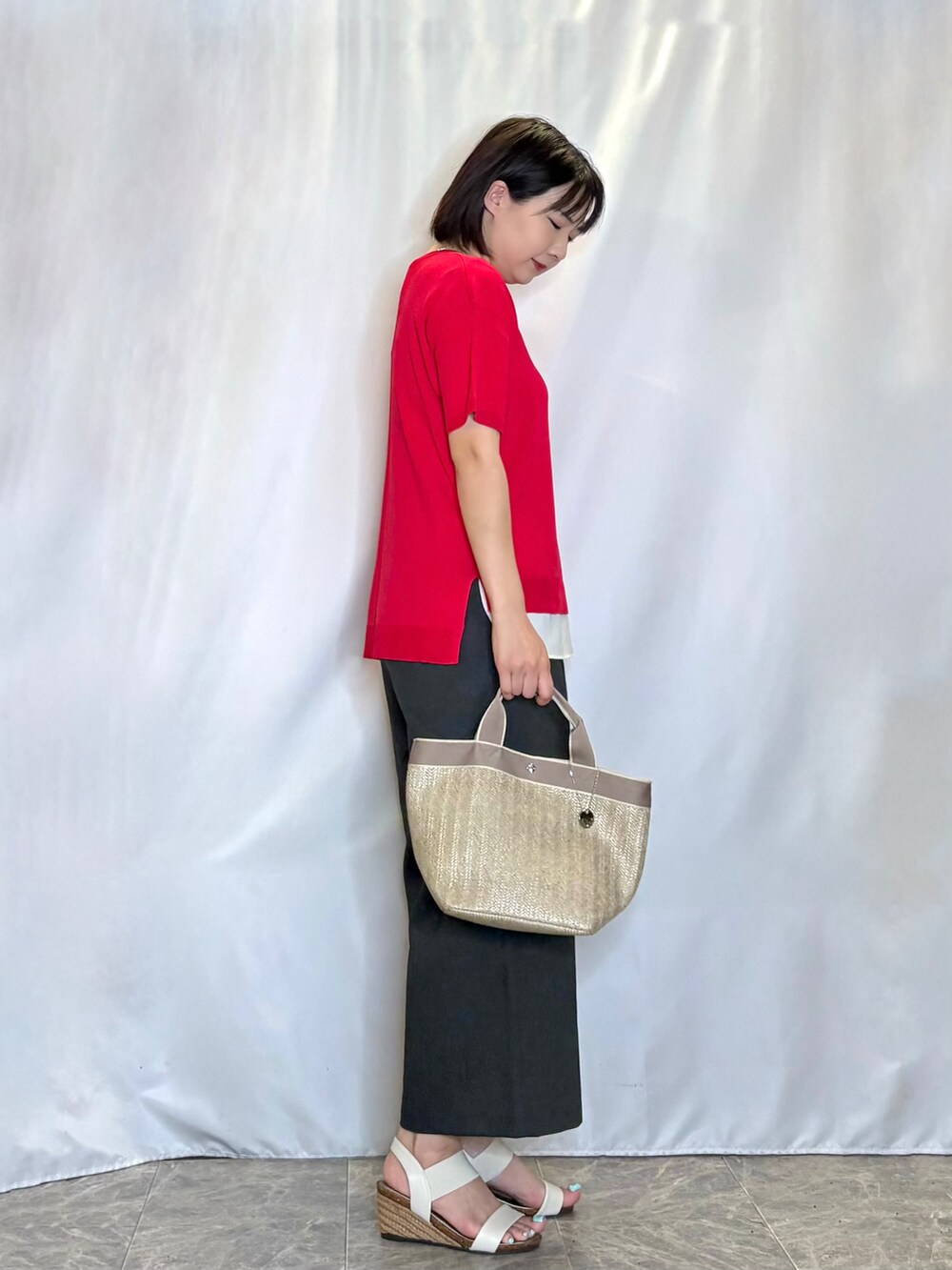 レッド系のニット/セーター、ブラック系のその他パンツ、ホワイト系のサンダルを着用したレディースの夏コーディネートの2枚目の写真