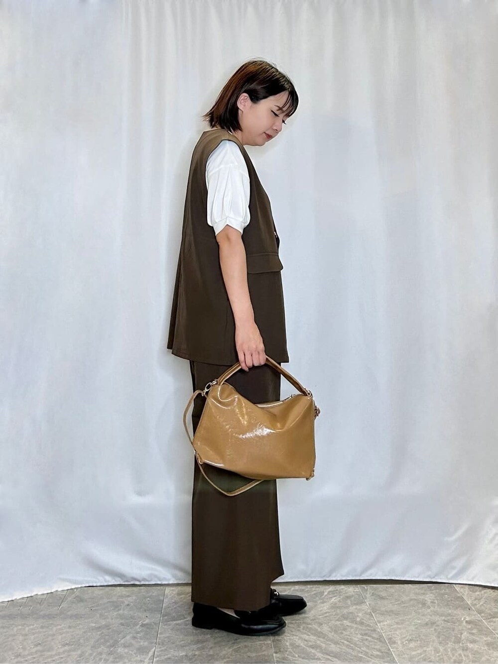 ブラウン系のベスト、ホワイト系のTシャツ/カットソー、ブラウン系のその他パンツを着用したレディースの夏コーディネートの2枚目の写真