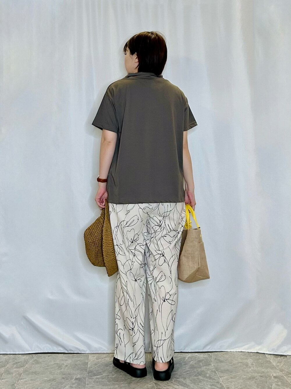 ホワイト系のその他パンツ、ブラック系のサンダル、イエロー系のトートバッグを着用したレディースの春コーディネートの3枚目の写真