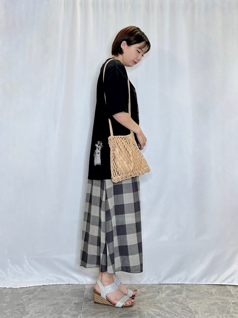 ブラック系のTシャツ/カットソー、グレー系のスカート、シルバー系のサンダルを着用したレディースの夏コーディネートの2枚目の写真