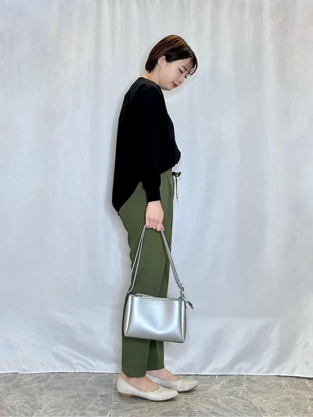 ブラック系のシャツ/ブラウス、グリーン系のその他パンツ、ゴールド系のその他シューズを着用したレディースの春コーディネートの2枚目の写真
