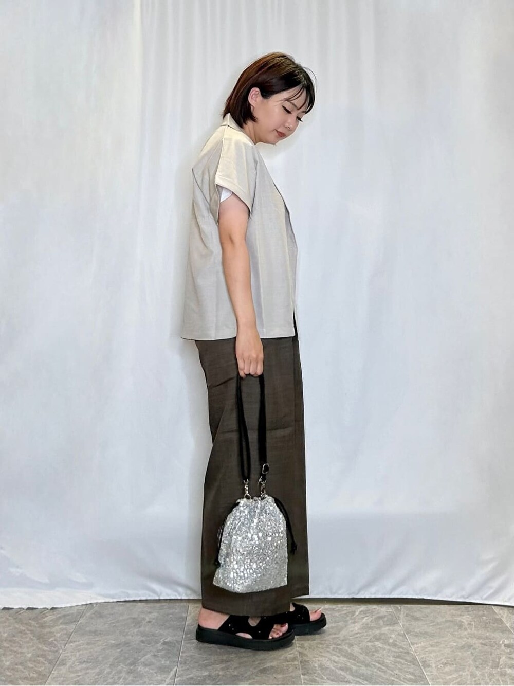 ベージュ系のテーラードジャケット、ホワイト系のTシャツ/カットソー、ブラウン系のその他パンツを着用したレディースの夏コーディネートの2枚目の写真