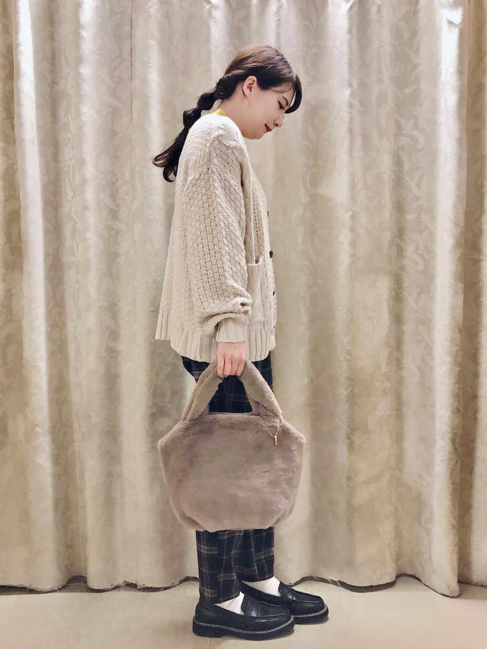 ブルー系のその他パンツ、イエロー系のニット/セーター、ブラック系のドレスシューズを着用したレディースの冬コーディネートの2枚目の写真
