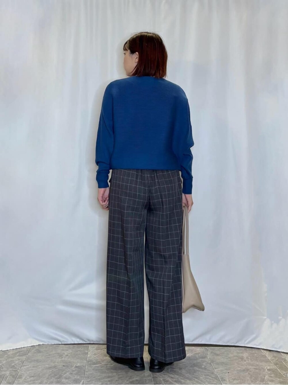 ブルー系のニット/セーター、グレー系のその他パンツ、ブラック系のその他シューズを着用したレディースの秋コーディネートの3枚目の写真