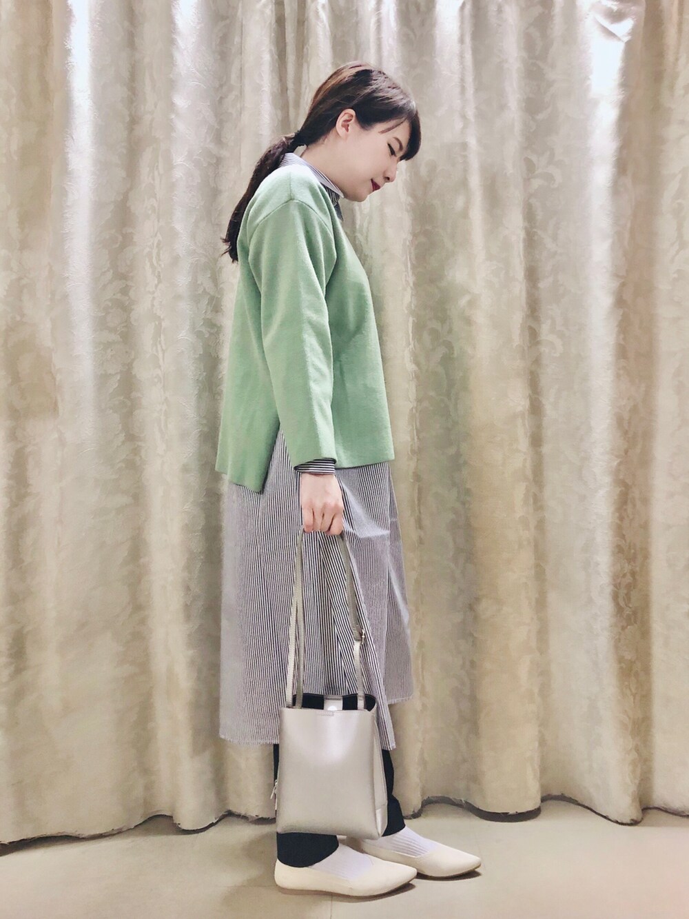 ブルー系のワンピース、グリーン系のニット/セーター、ブラック系のその他パンツを着用したレディースの冬コーディネートの2枚目の写真