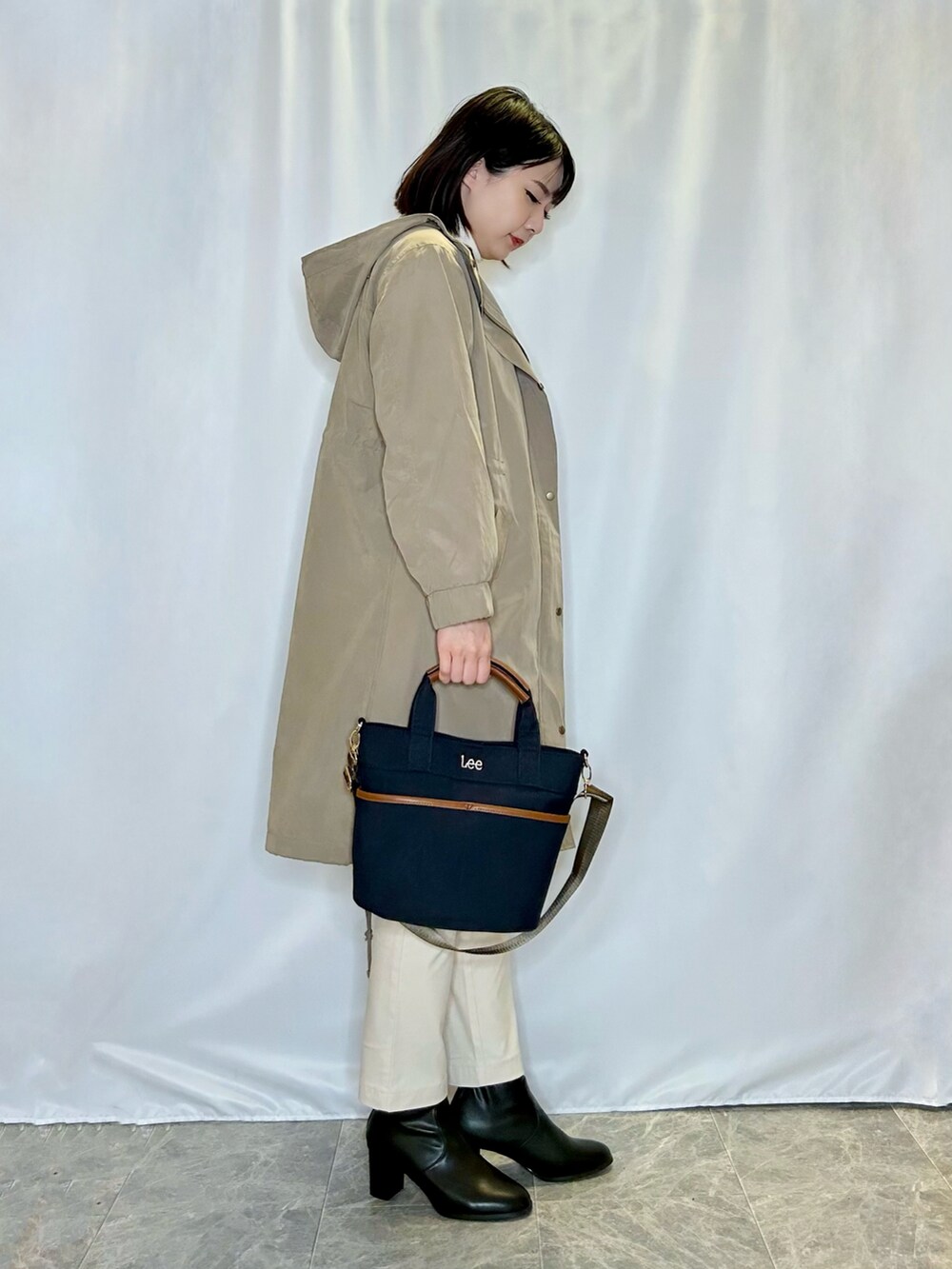 ホワイト系のその他パンツ、ブラック系のブーツ、ブルー系のトートバッグを着用したレディースの秋コーディネートの2枚目の写真