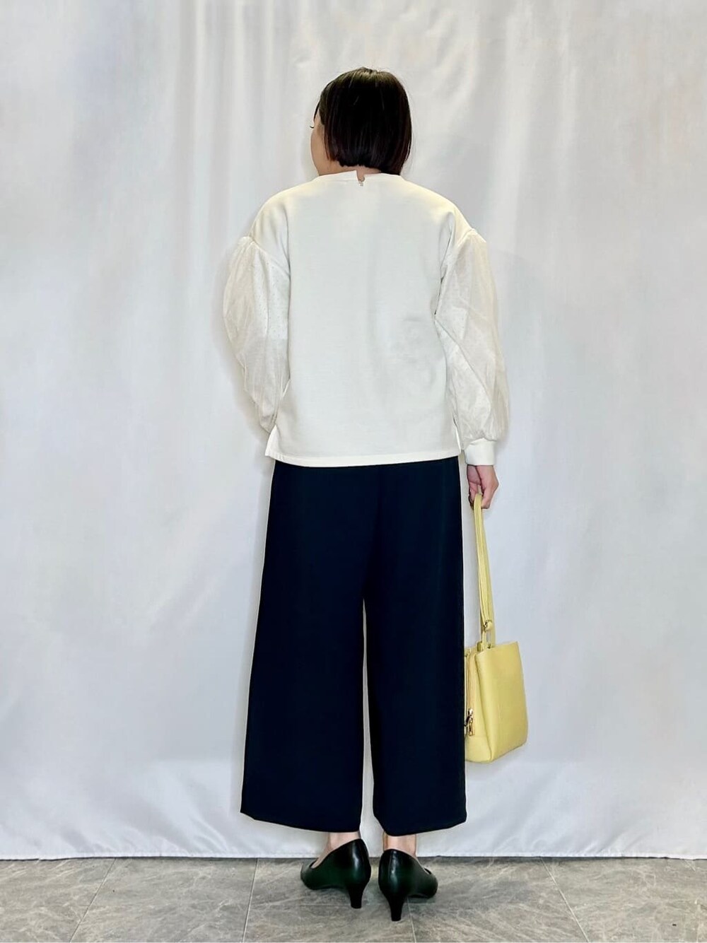 ホワイト系のTシャツ/カットソー、ブルー系のその他パンツ、ブラック系のパンプスを着用したレディースの冬コーディネートの3枚目の写真