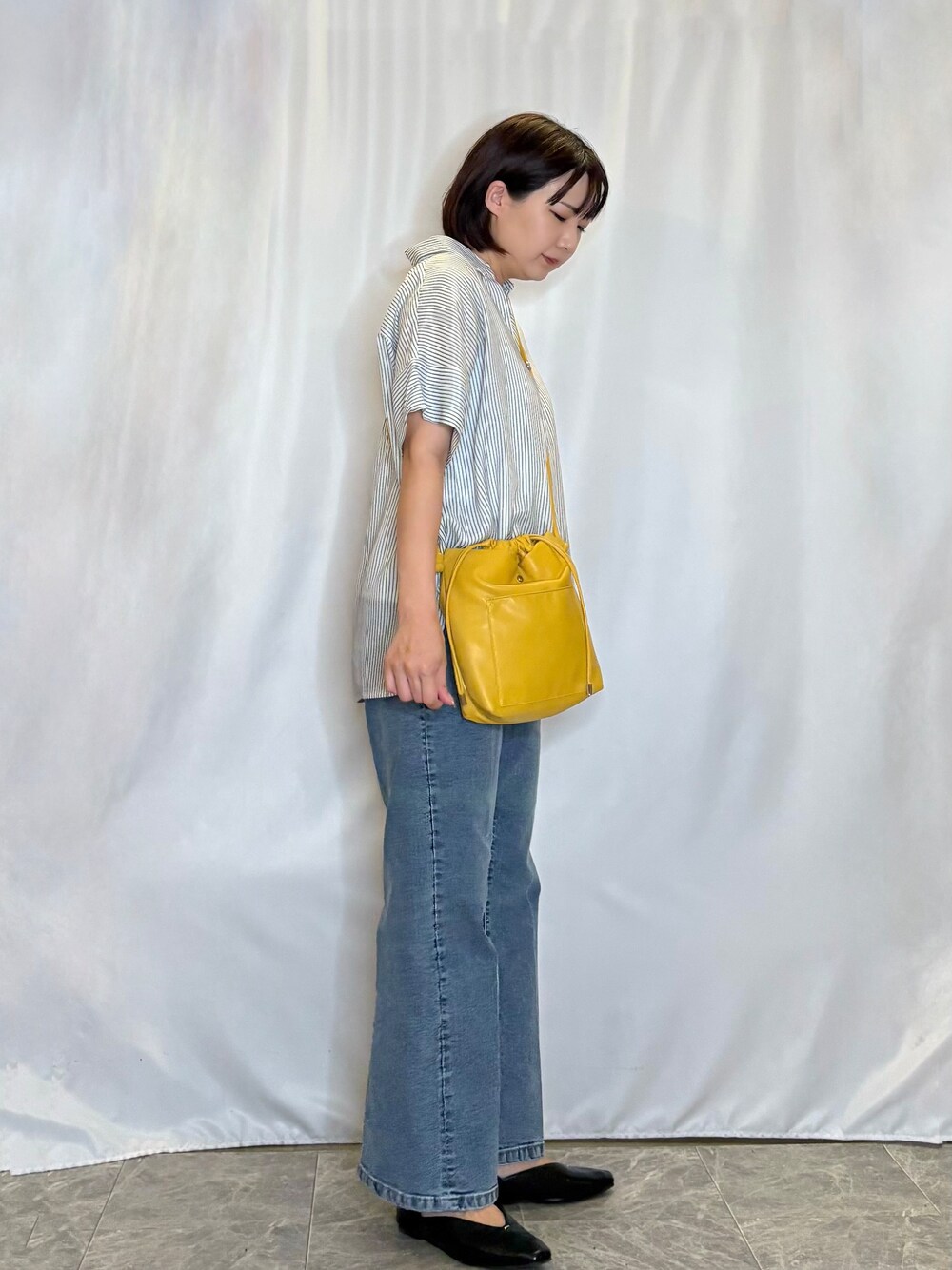 ホワイト系のその他トップス、ブルー系のデニムパンツ、イエロー系のショルダーバッグを着用したレディースの秋コーディネートの2枚目の写真