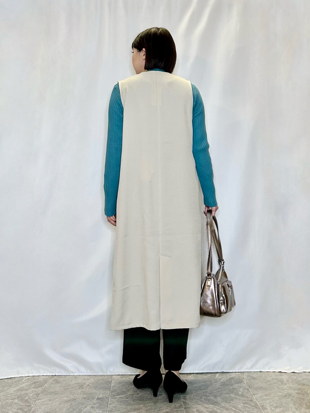 ベージュ系のベスト、その他のショルダーバッグ、ブラック系のパンプスを着用したレディースの冬コーディネートの3枚目の写真