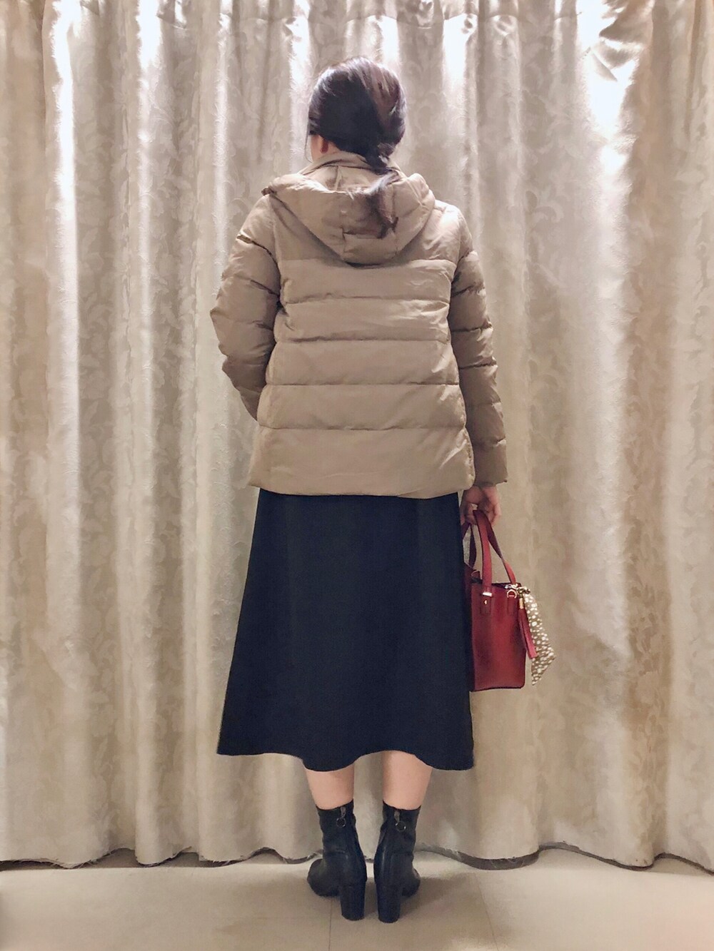 ブラック系のスカート、ベージュ系のTシャツ/カットソー、レッド系のショルダーバッグを着用したレディースの秋コーディネートの3枚目の写真