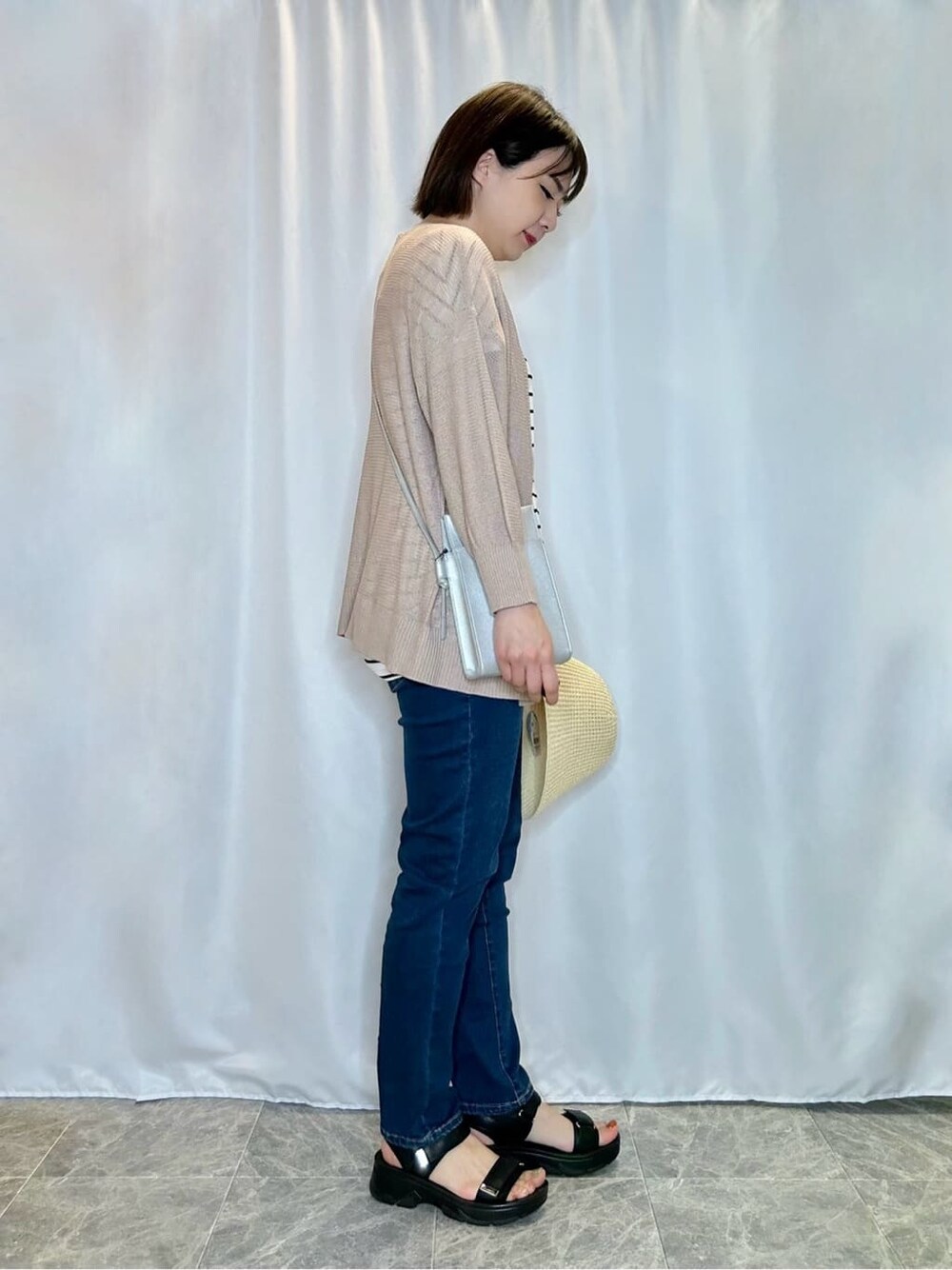 ブルー系のデニムパンツを着用したレディースの春コーディネートの2枚目の写真