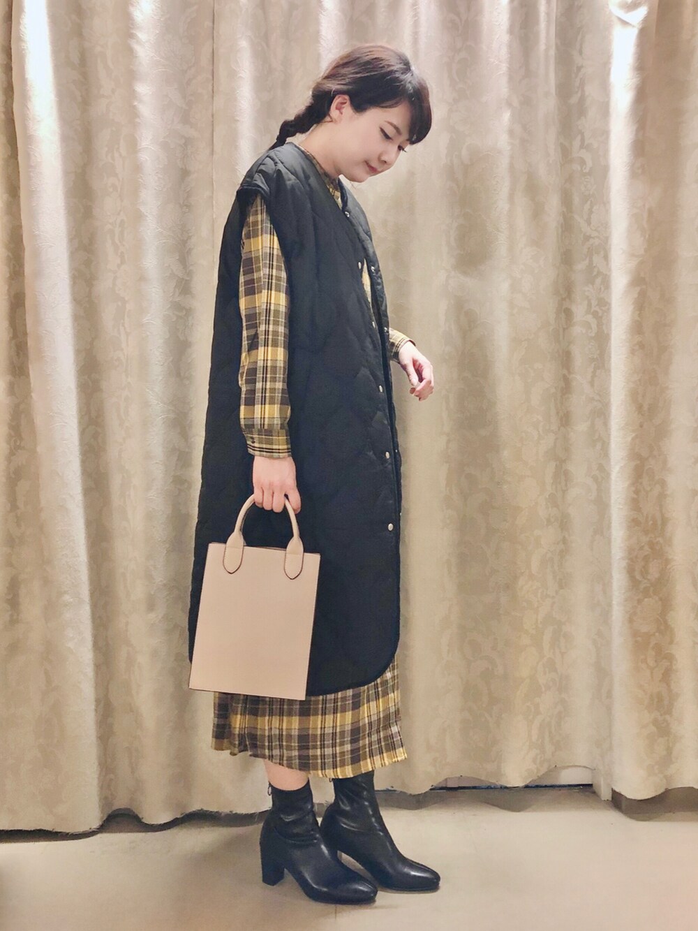 グレー系のショルダーバッグ、ブラック系のブーツ、イエロー系のワンピースを着用したレディースの秋コーディネートの2枚目の写真