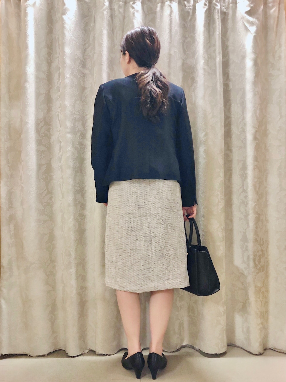 ブルー系のノーカラージャケット、ブラック系のパンプス、グレー系のワンピースを着用したレディースの春コーディネートの3枚目の写真