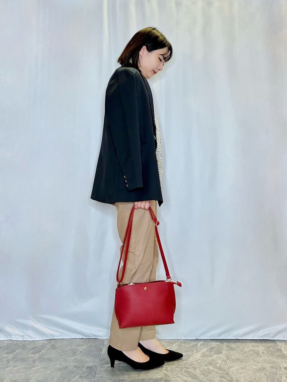 ブルー系のテーラードジャケット、ブラウン系のその他パンツ、レッド系のショルダーバッグを着用したレディースの秋コーディネートの2枚目の写真