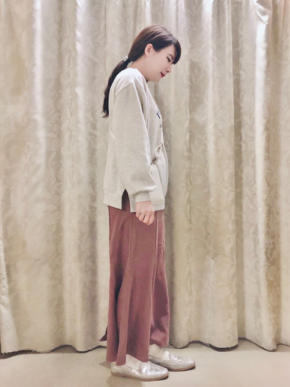 ピンク系のスカート、ベージュ系のスウェット、ホワイト系のTシャツ/カットソーを着用したレディースの春コーディネートの2枚目の写真