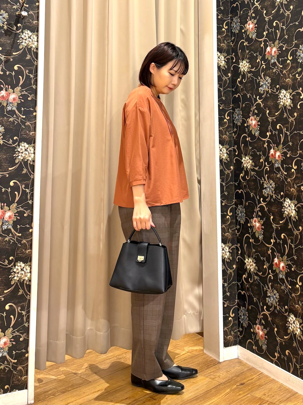 オレンジ系のシャツ/ブラウス、ブラウン系のその他パンツ、ブラック系のショルダーバッグを着用したレディースの秋コーディネートの2枚目の写真