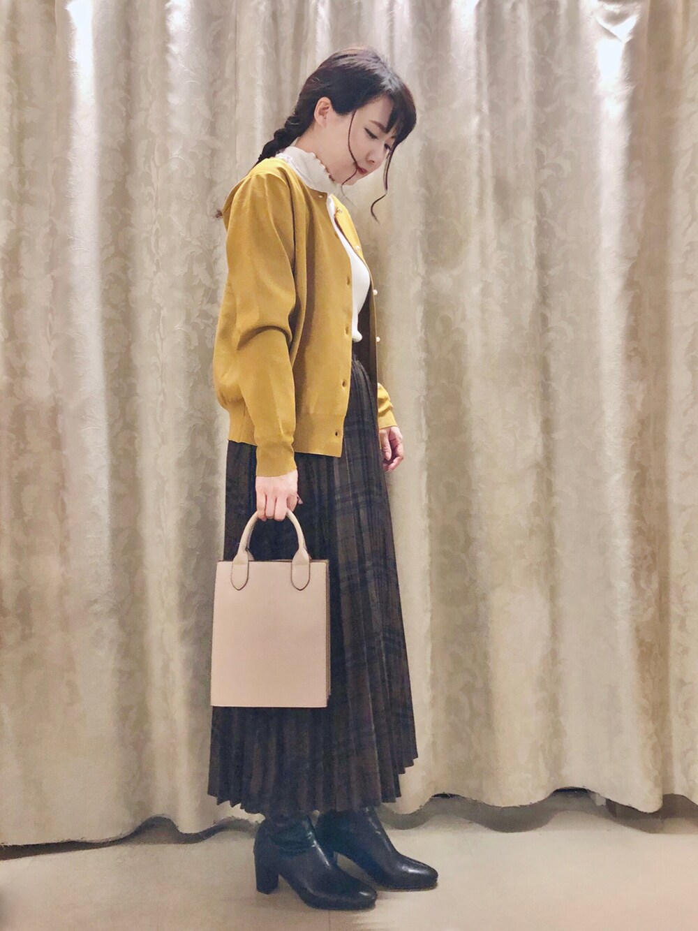 ホワイト系のTシャツ/カットソー、イエロー系のカーディガン/ボレロ、ブラック系のブーツを着用したレディースの秋コーディネートの2枚目の写真