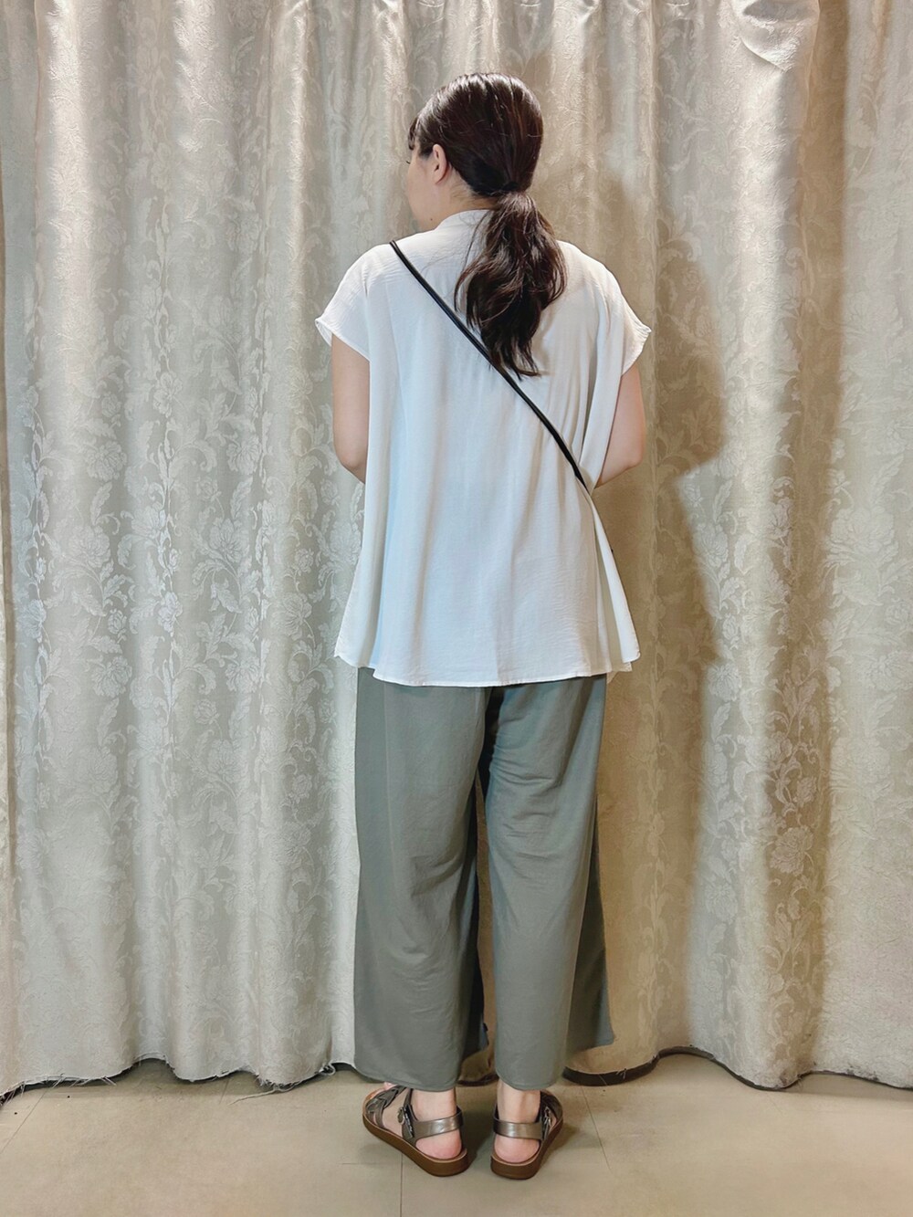 ベージュ系のタンクトップ、その他のサンダル、グリーン系のその他パンツを着用したレディースの夏コーディネートの3枚目の写真