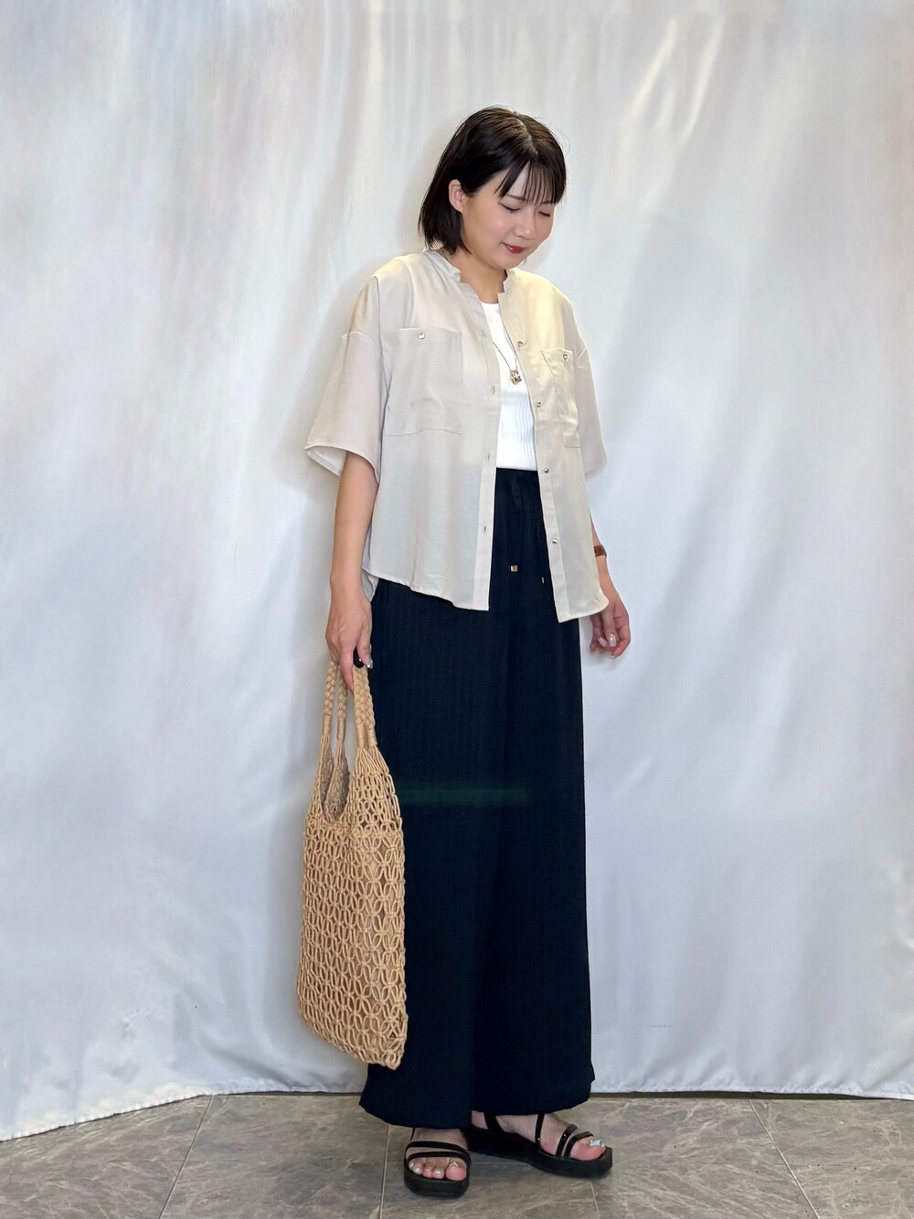 ベージュ系のシャツ/ブラウス、ホワイト系のタンクトップ、ブラック系のサンダルを着用したレディースの夏コーディネートの2枚目の写真