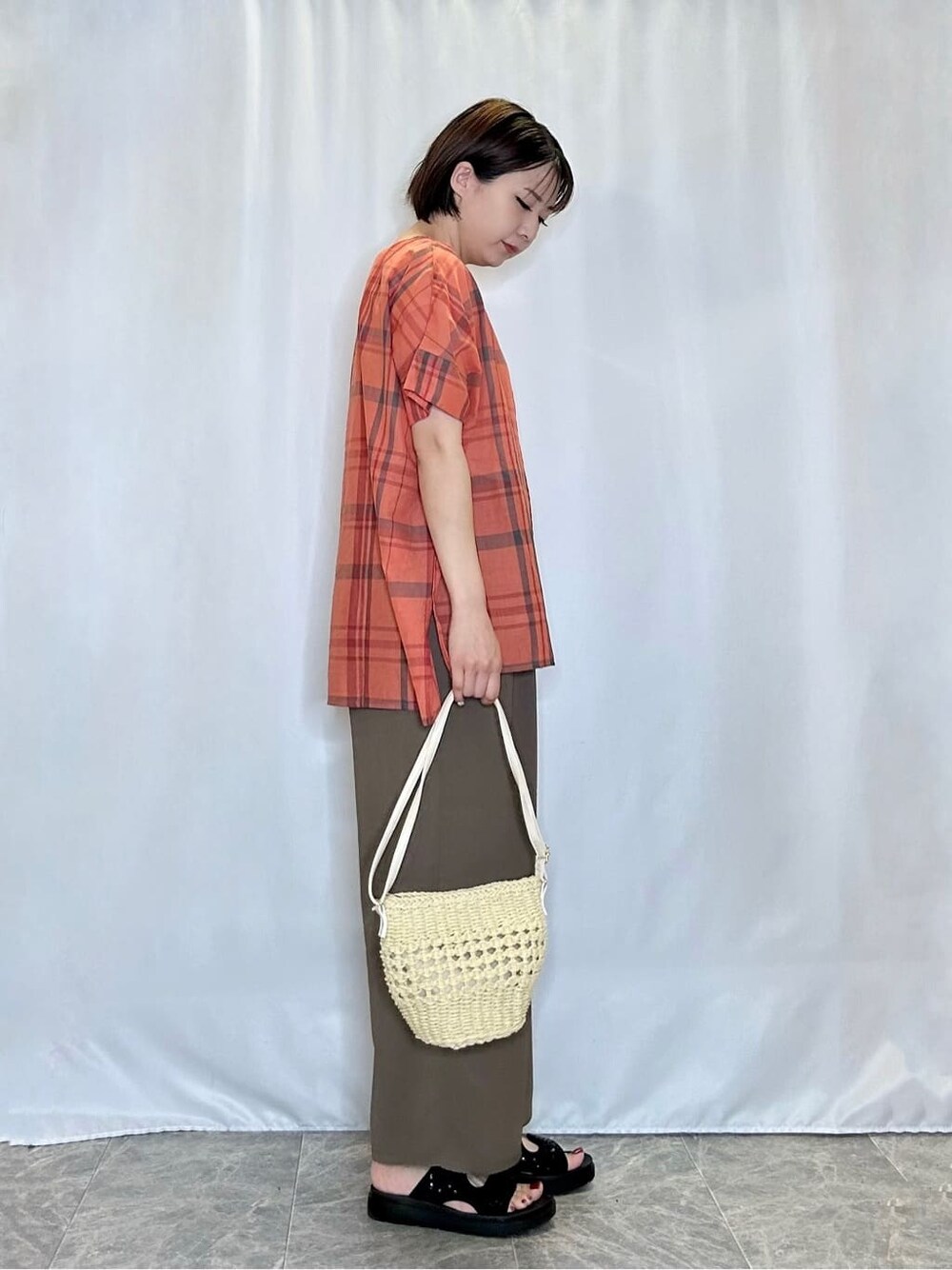 オレンジ系のシャツ/ブラウス、ブラウン系のその他パンツ、ブラック系のサンダルを着用したレディースの夏コーディネートの2枚目の写真