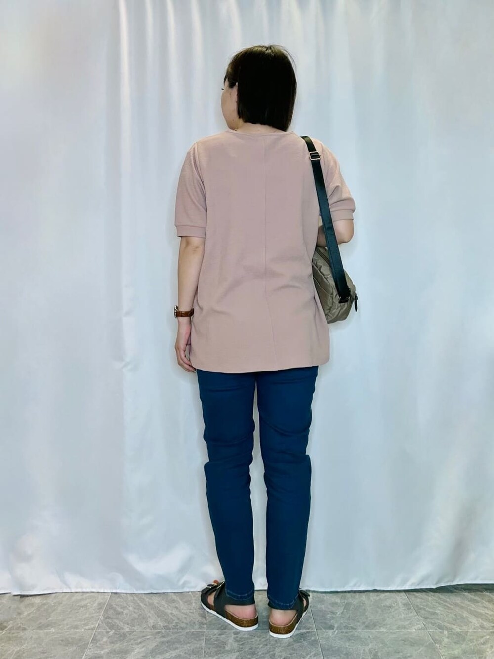 ブルー系のデニムパンツを着用したレディースの春コーディネートの3枚目の写真