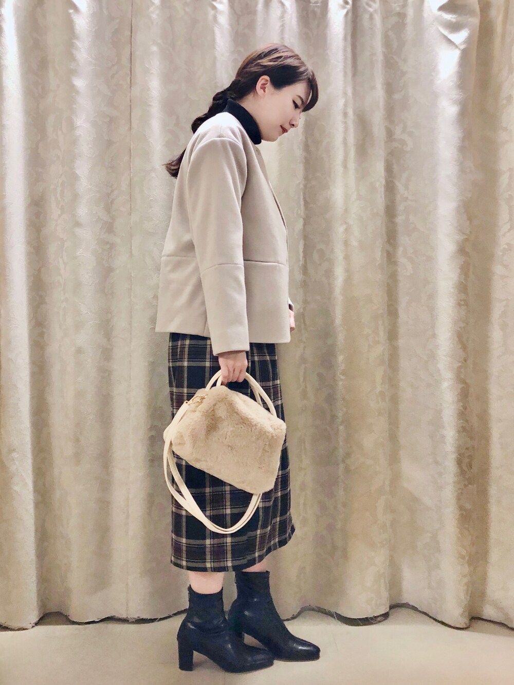 ブラック系のニット/セーター、ブラック系のスカート、ブラック系のブーツを着用したレディースの秋コーディネートの2枚目の写真