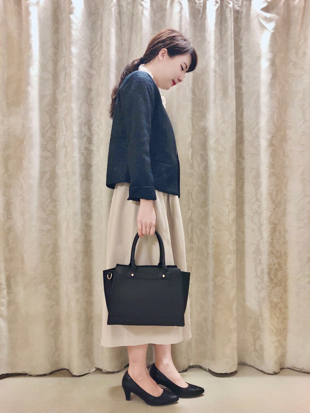 ブラック系のパンプス、ブラック系のトートバッグ、ホワイト系のシャツ/ブラウスを着用したレディースの春コーディネートの2枚目の写真