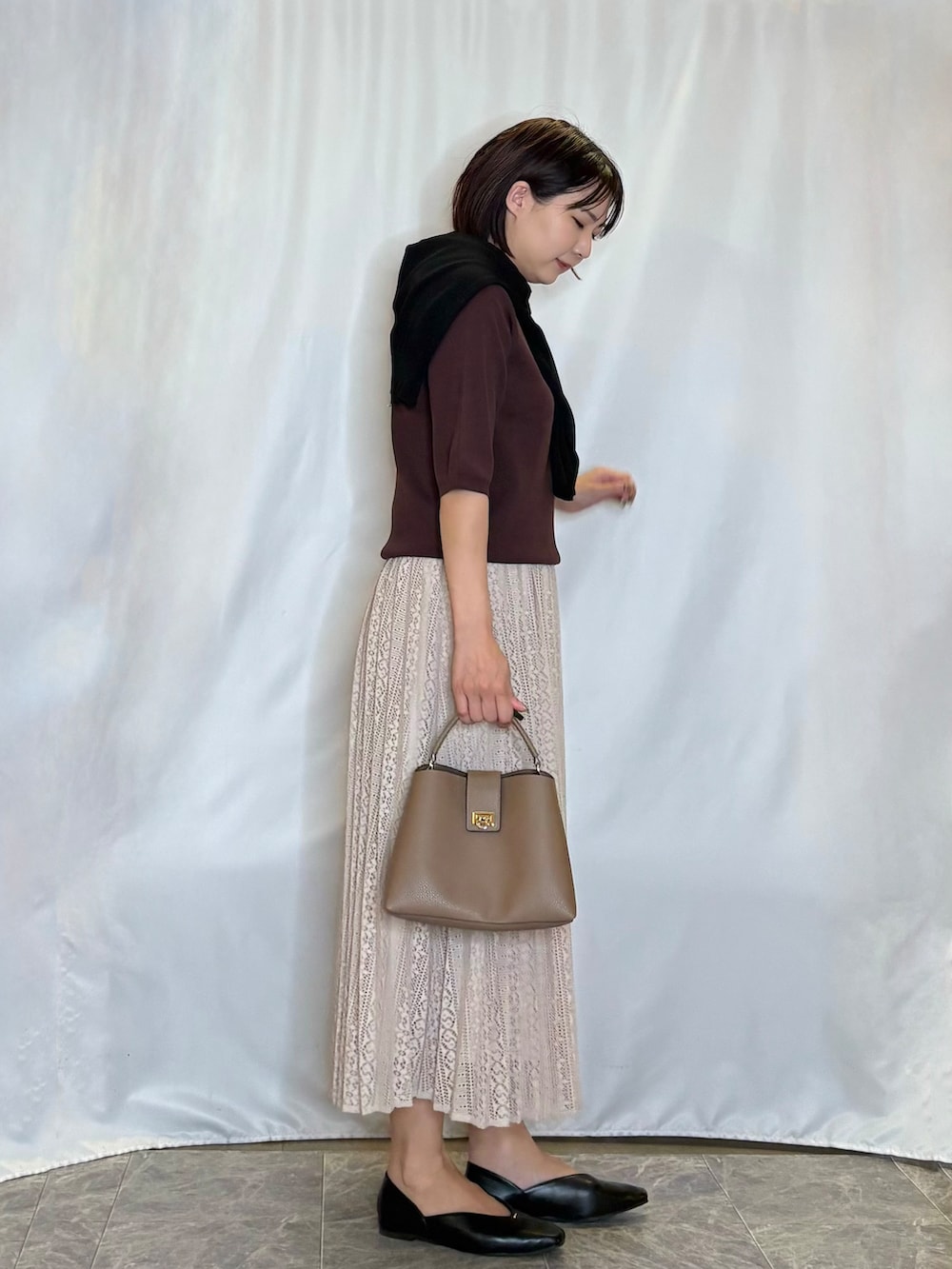 ブラック系のカーディガン/ボレロ、ブラウン系のニット/セーター、ベージュ系のスカートを着用したレディースの夏コーディネートの2枚目の写真