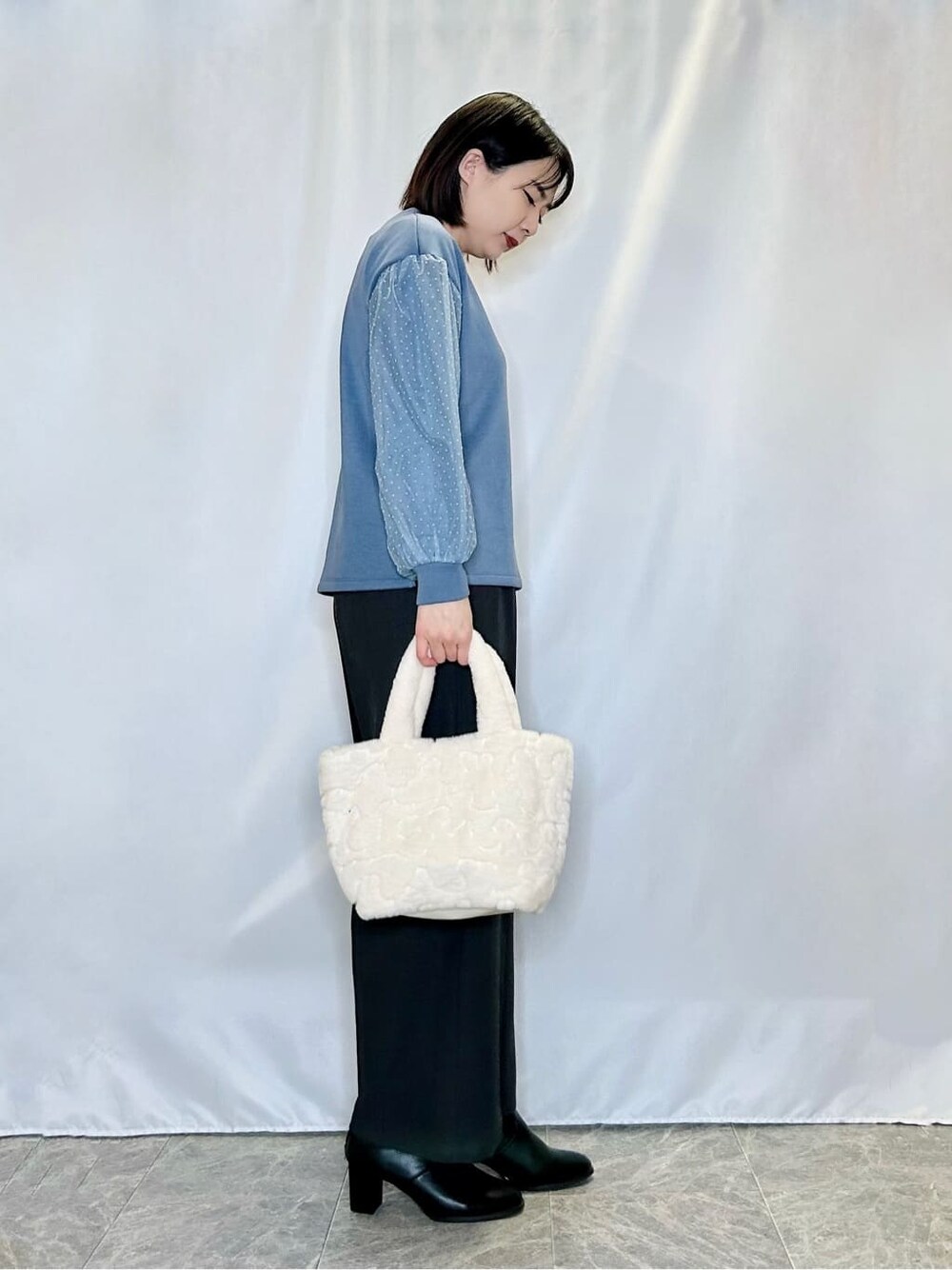 ブルー系のTシャツ/カットソーを着用したレディースの冬コーディネートの2枚目の写真
