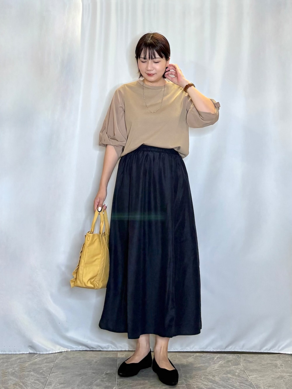 ブラウン系のTシャツ/カットソー、ブルー系のスカート、ブラック系のパンプスを着用したレディースの夏コーディネートの2枚目の写真
