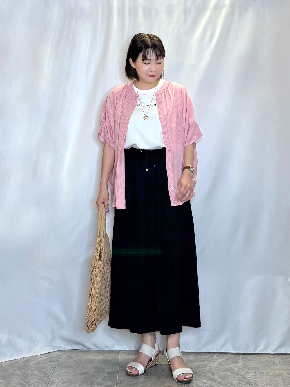 ピンク系のシャツ/ブラウス、ホワイト系のTシャツ/カットソー、ブラック系のスカートを着用したレディースの夏コーディネートの2枚目の写真