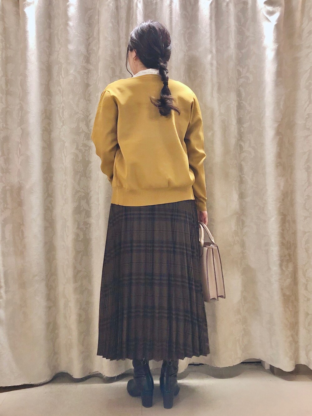 ホワイト系のTシャツ/カットソー、イエロー系のカーディガン/ボレロ、ブラック系のブーツを着用したレディースの秋コーディネートの3枚目の写真