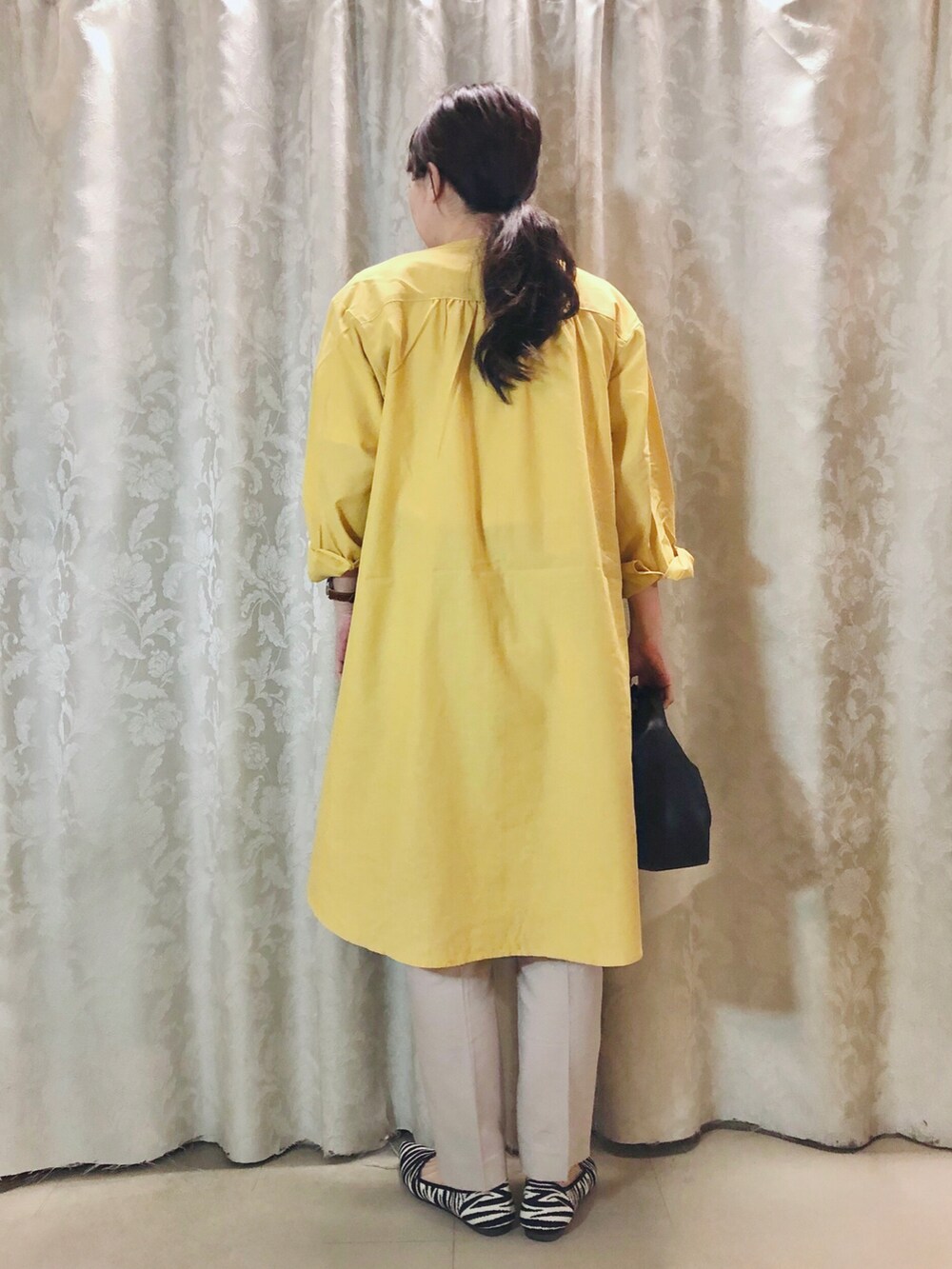 ホワイト系のTシャツ/カットソー、イエロー系のワンピース、ブラック系のパンプスを着用したレディースの春コーディネートの3枚目の写真