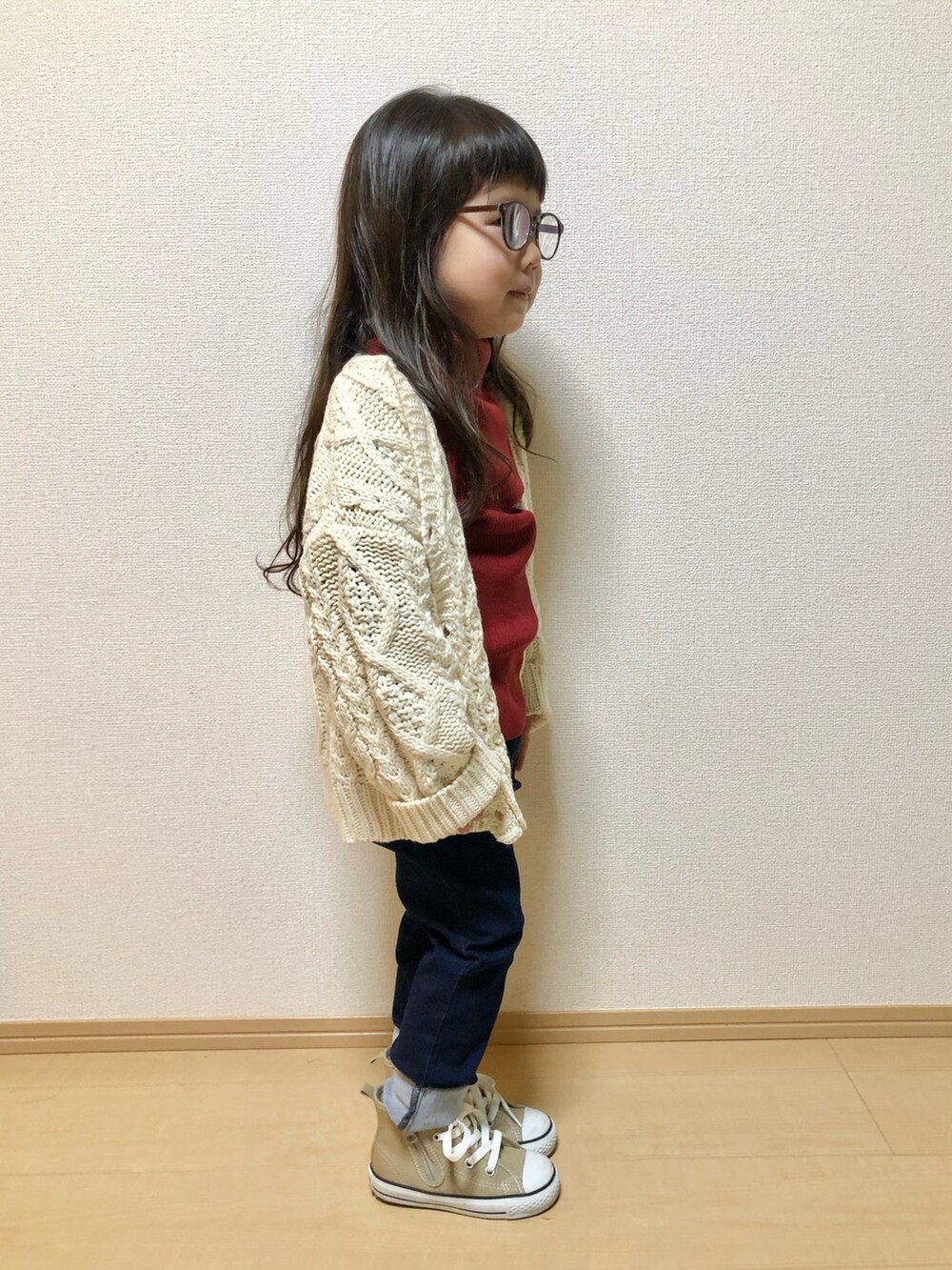 レッド系のニット/セーター、ホワイト系のカーディガン/ボレロ、ブルー系のその他パンツを着用したレディースの秋コーディネートの2枚目の写真