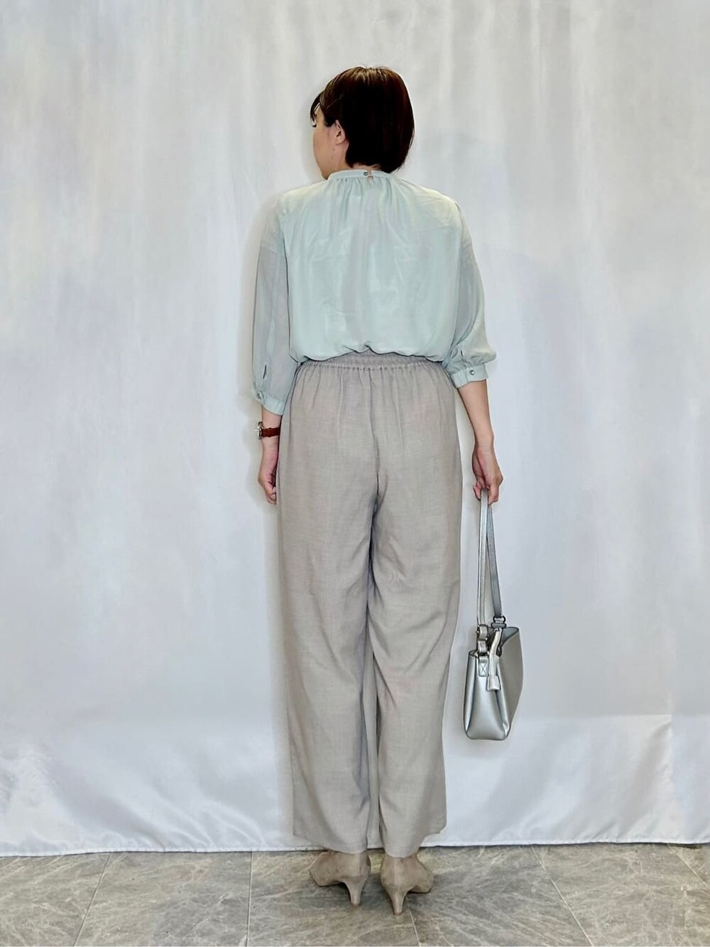 グリーン系のシャツ/ブラウス、ベージュ系のその他パンツ、シルバー系のショルダーバッグを着用したレディースの春コーディネートの3枚目の写真