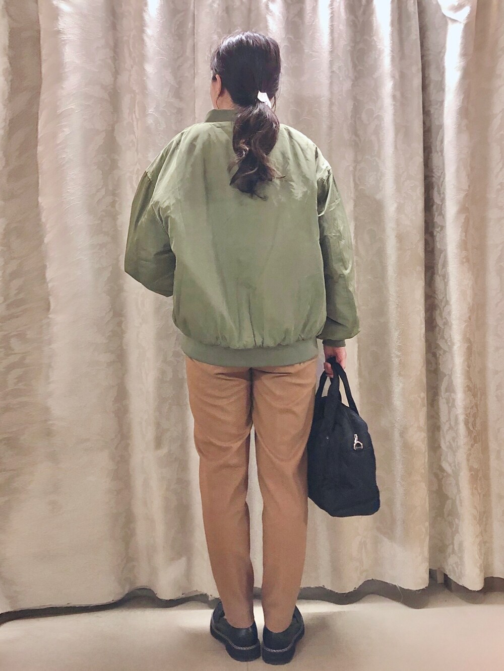 ブラック系のドレスシューズ、グリーン系のブルゾン、ホワイト系のTシャツ/カットソーを着用したレディースの秋コーディネートの3枚目の写真