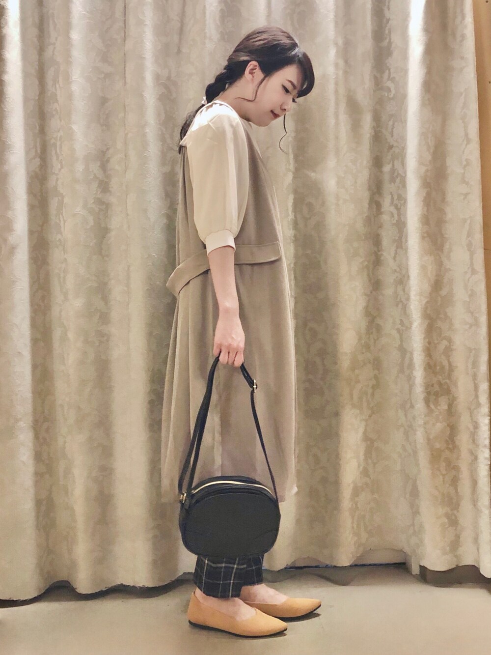 イエロー系のパンプス、ベージュ系のベスト、ホワイト系のTシャツ/カットソーを着用したレディースの秋コーディネートの2枚目の写真