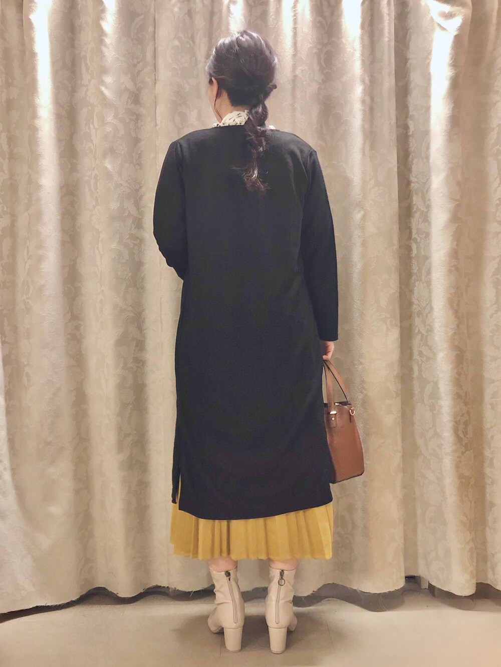 ホワイト系のシャツ/ブラウス、ブラック系のカーディガン/ボレロ、イエロー系のスカートを着用したレディースの秋コーディネートの3枚目の写真