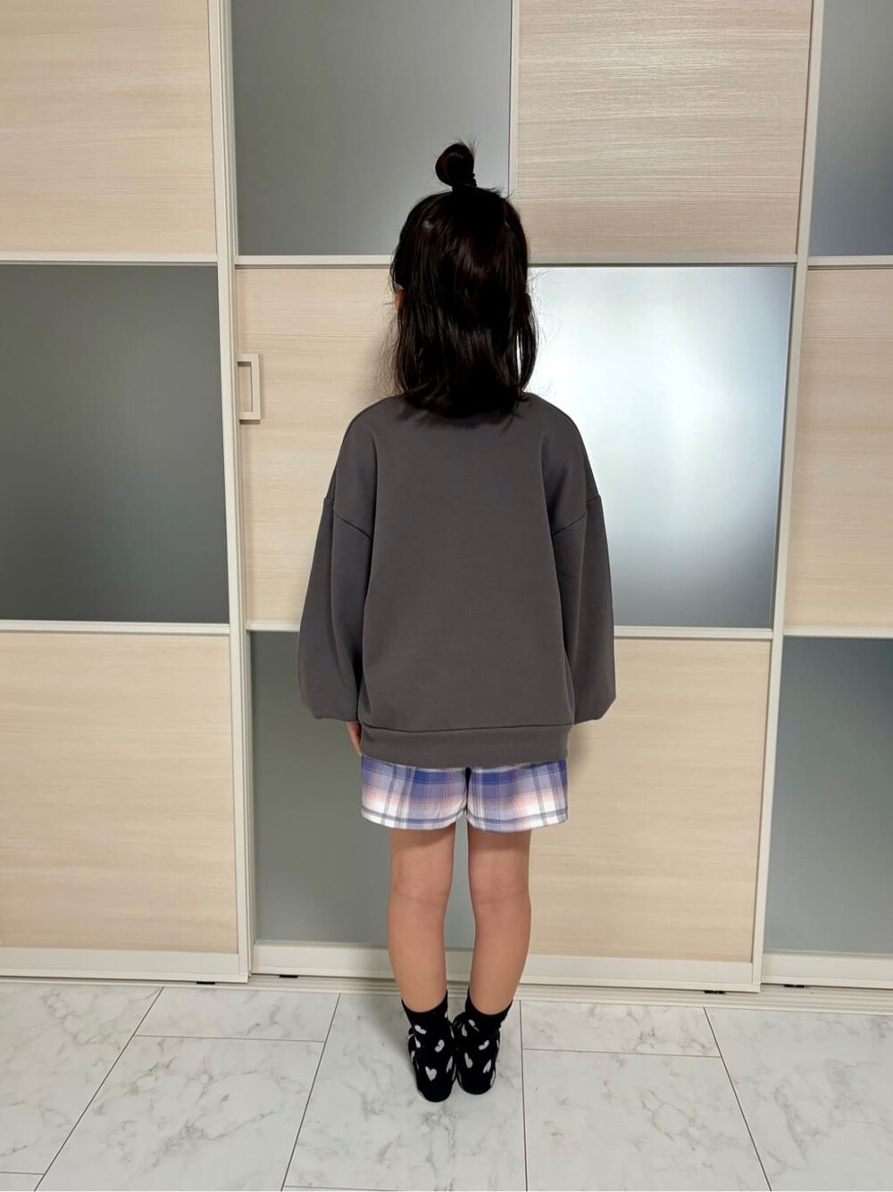 グレー系のスウェット、パープル系のスカートを着用したレディースの冬コーディネートの3枚目の写真