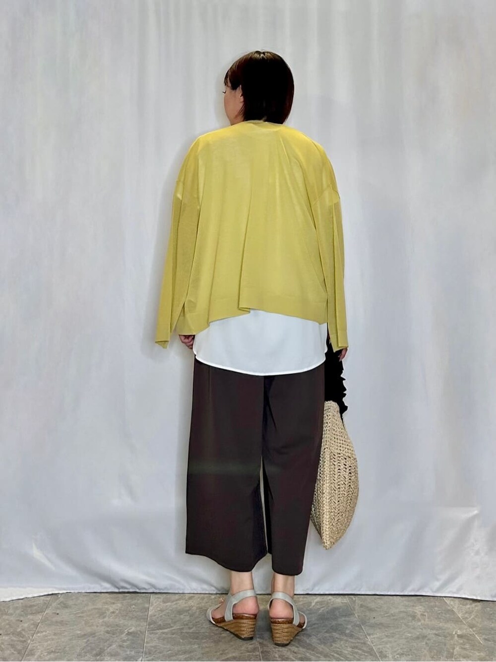イエロー系のカーディガン/ボレロ、ホワイト系のシャツ/ブラウス、ブラウン系のその他パンツを着用したレディースの夏コーディネートの3枚目の写真