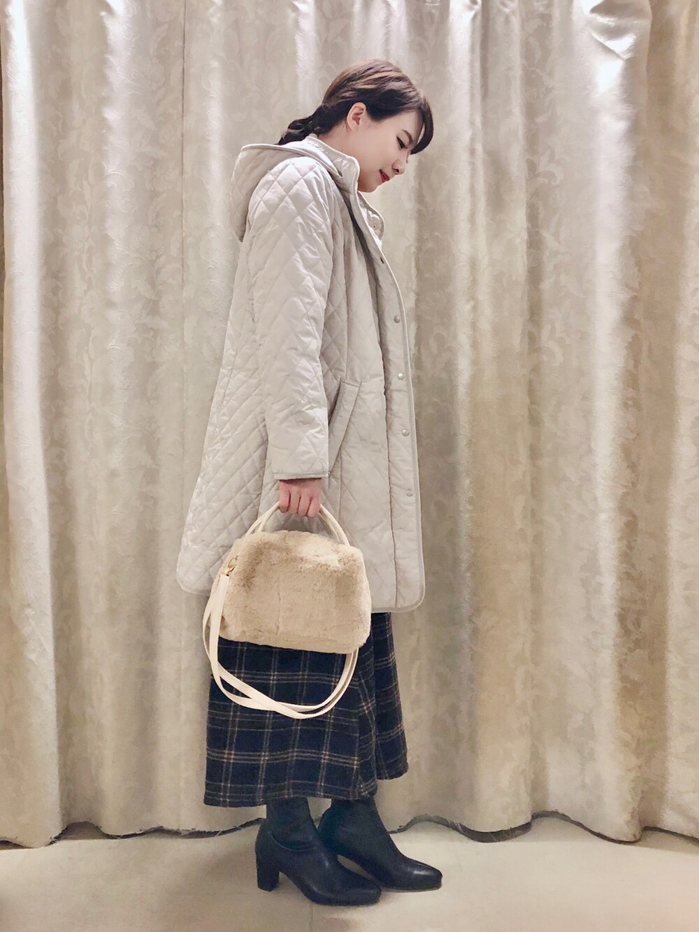 イエロー系のニット/セーター、ブルー系のスカート、ブラック系のブーツを着用したレディースの秋コーディネートの2枚目の写真