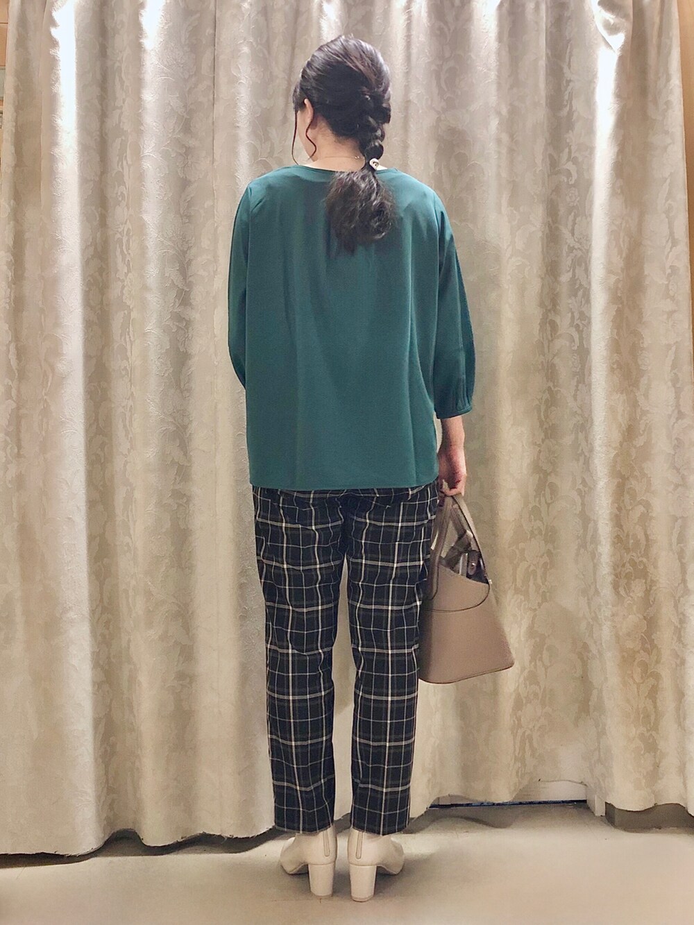 ベージュ系のトートバッグ、ホワイト系のブーツ、グリーン系のTシャツ/カットソーを着用したレディースの秋コーディネートの3枚目の写真