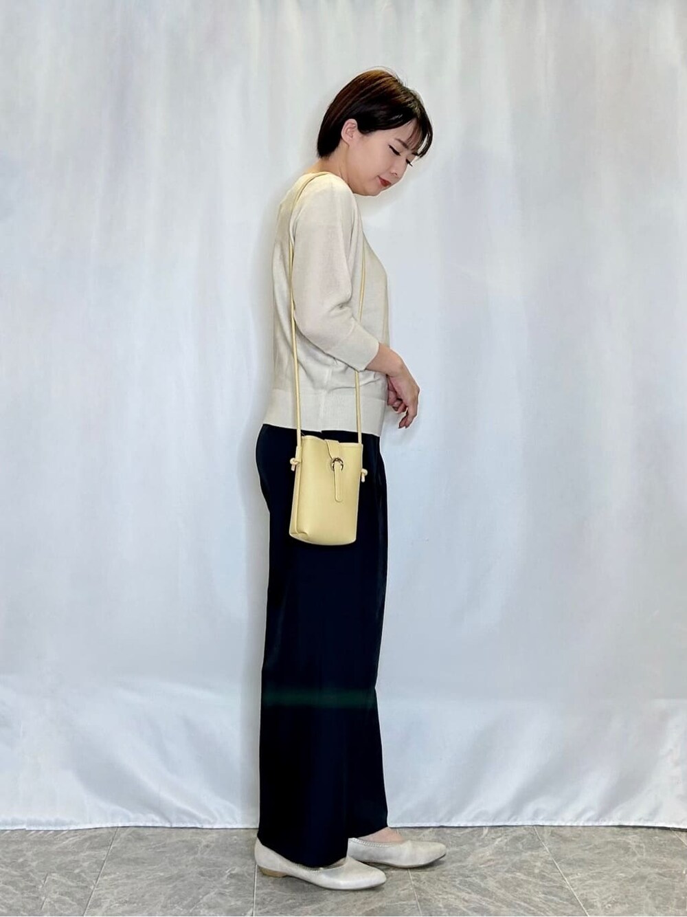 ホワイト系のニット/セーター、グレー系のその他パンツ、ゴールド系のその他シューズを着用したレディースの春コーディネートの2枚目の写真