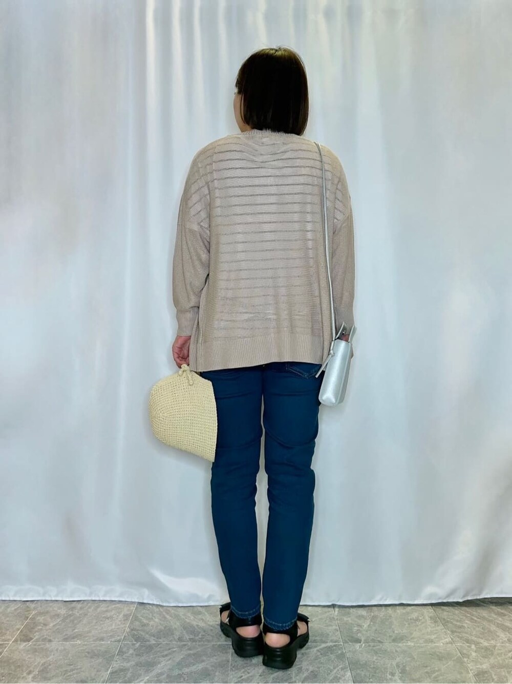 ブルー系のデニムパンツを着用したレディースの春コーディネートの3枚目の写真