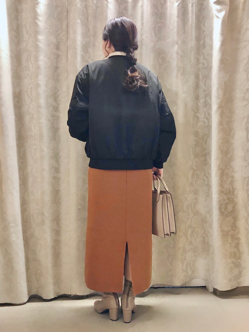 ベージュ系のブーツ、ホワイト系のニット/セーター、グレー系のショルダーバッグを着用したレディースの秋コーディネートの3枚目の写真