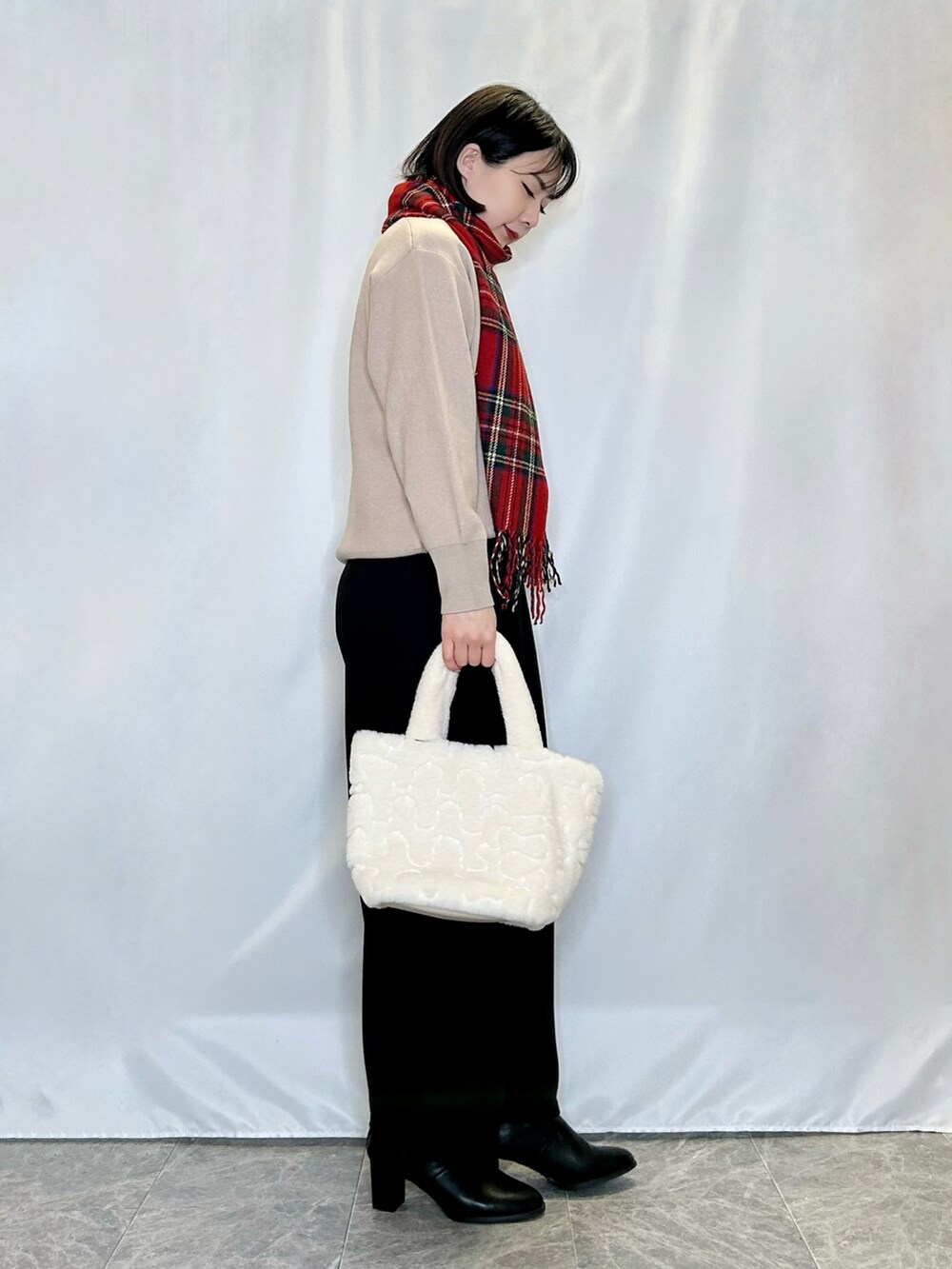 ブラック系のブーツ、ベージュ系のトートバッグ、ベージュ系のニット/セーターを着用したレディースの冬コーディネートの2枚目の写真